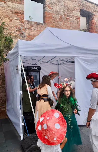 Návštěvníci v pohádkových kostýmech před nůžkovým stanem na festivalu v Jičíně.
